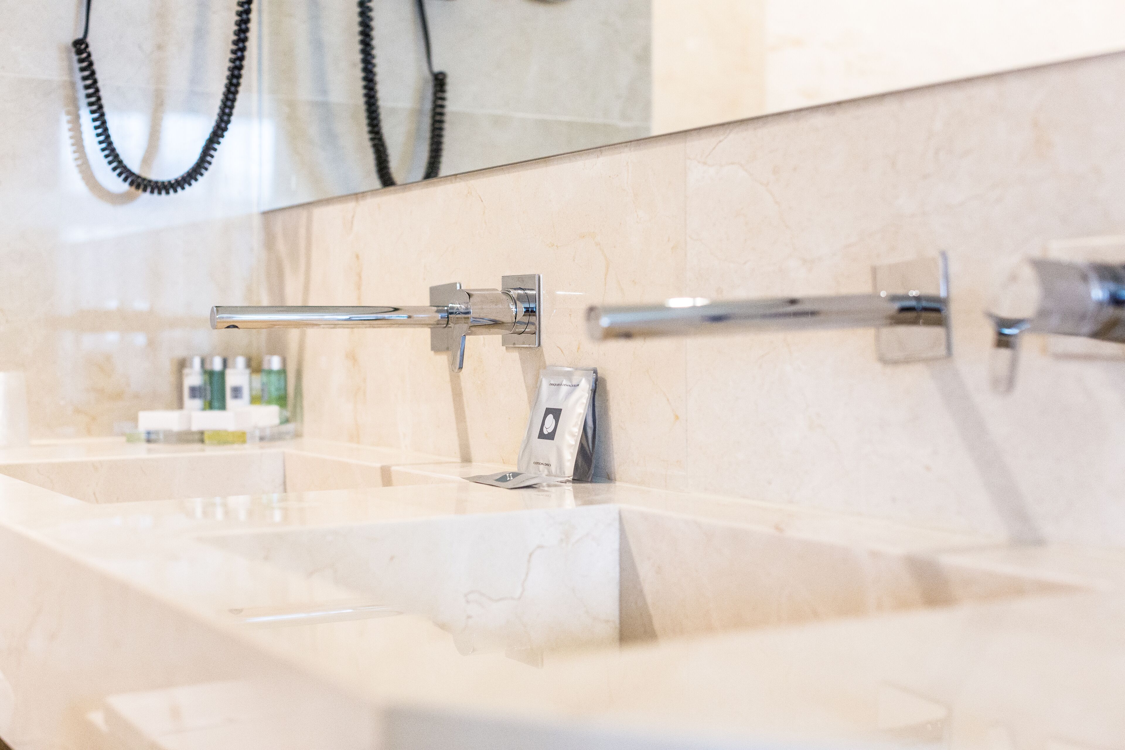 Un baño con un espejo grande, un lavabo y un perchero para toallas.