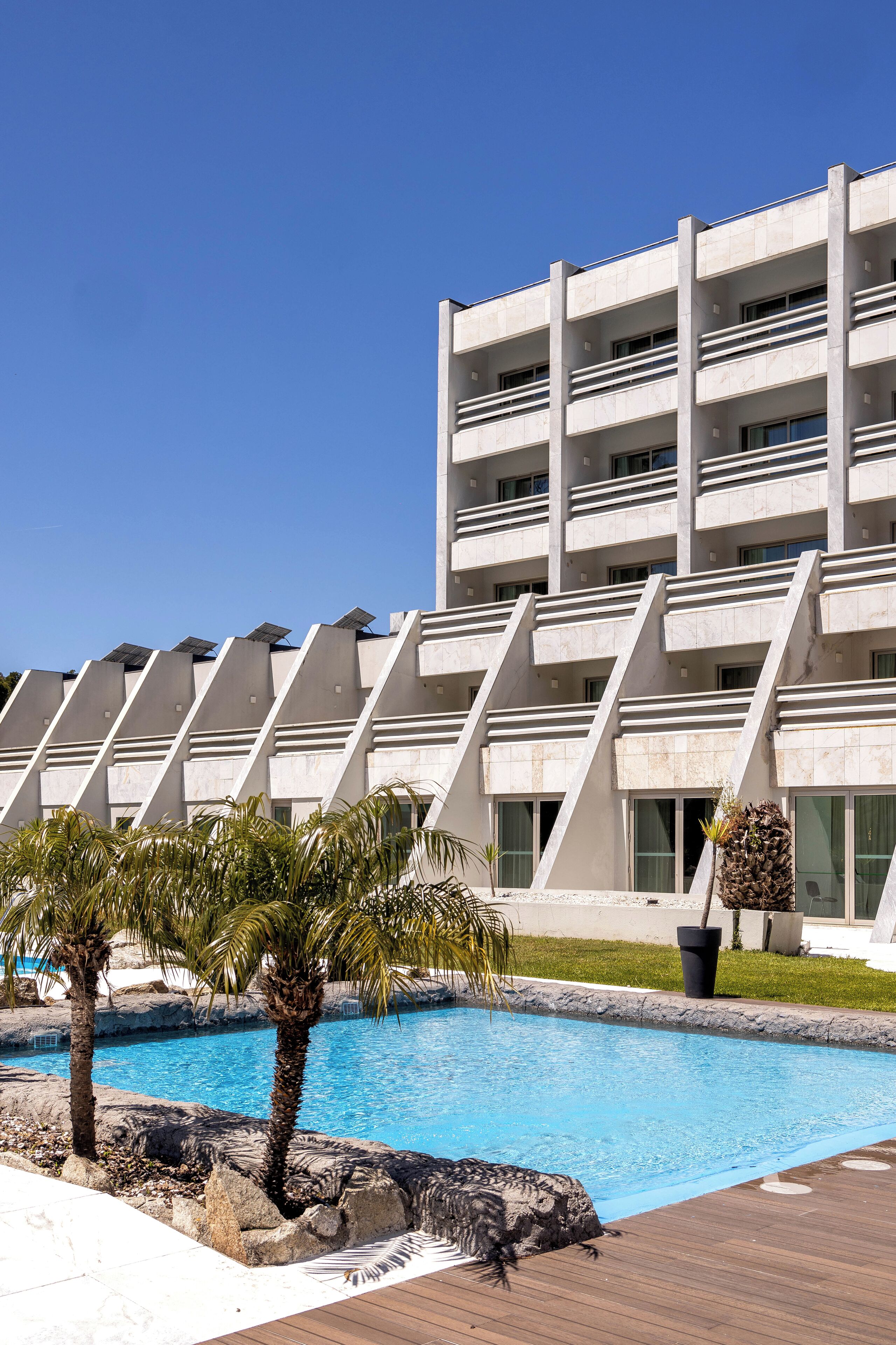 Un edificio moderno con piscina y palmeras.