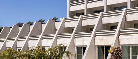 Un edificio moderno con piscina y palmeras.