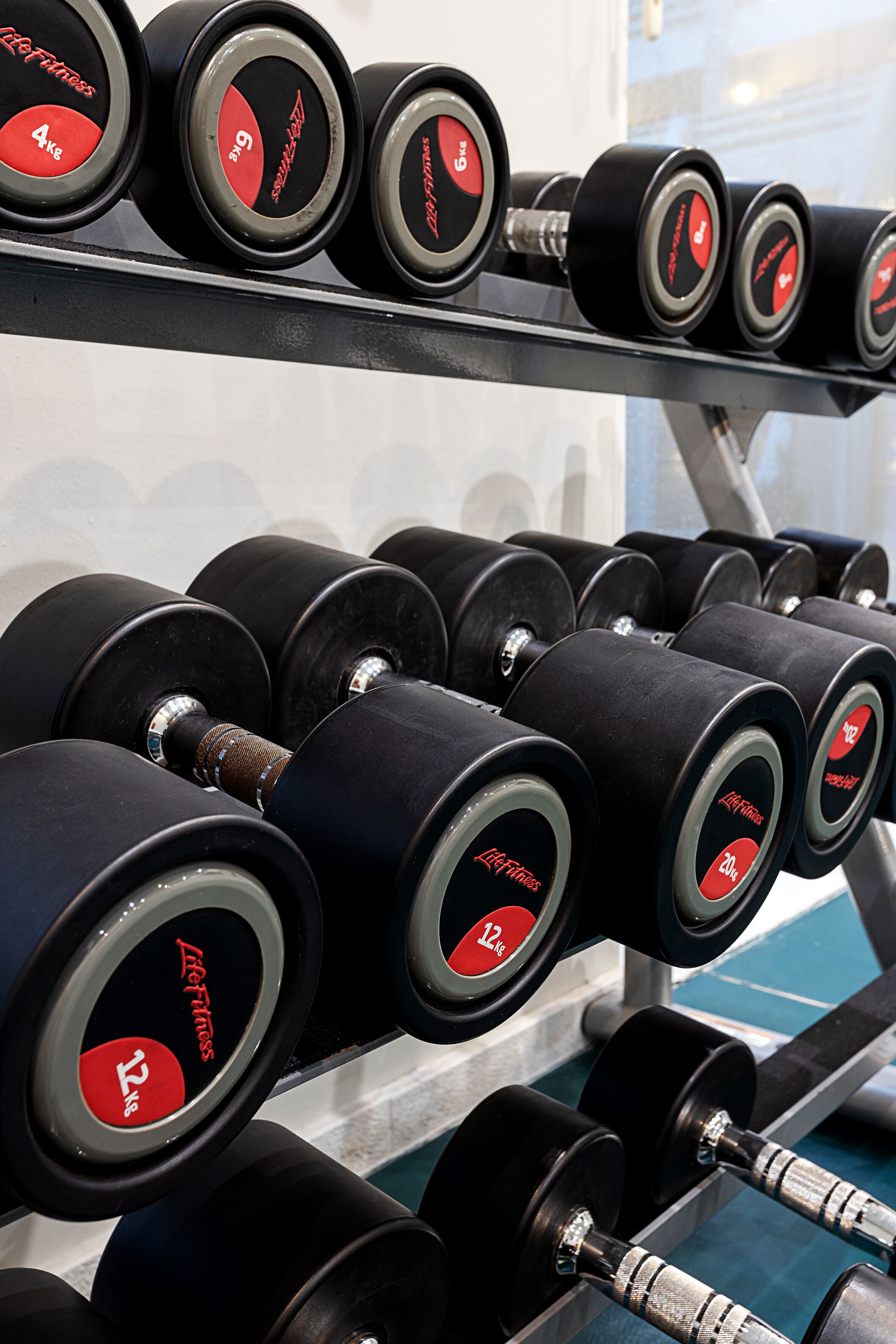A rack of dumbbells with weight labels.