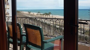 A balcony with a view of the beach and ocean.