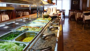 A buffet area with multiple food stations, stainless steel serving trays, and a variety of dishes.
