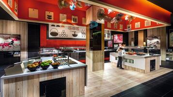 Une cuisine moderne avec des plans de travail en bois, un présentoir à fruits et des œuvres d’art décoratives au mur.