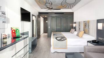 Una habitación de hotel moderna con cama, escritorio, silla y ventilador de techo.