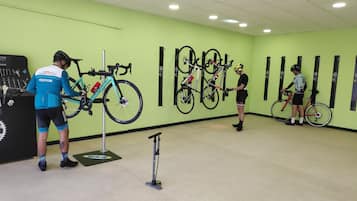 A cycling training room with multiple bikes, a bike rack, and a stationary bike.