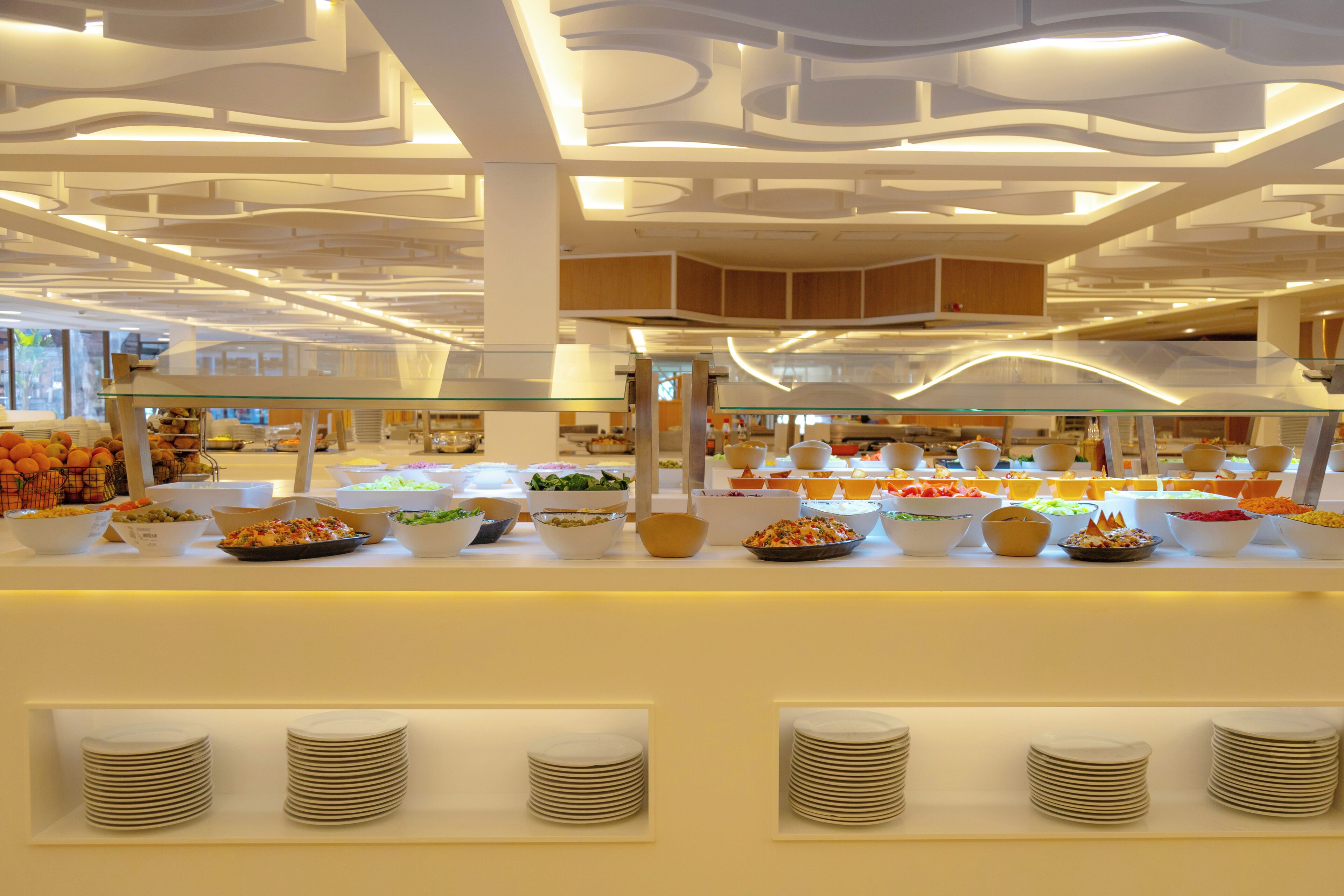 Zona de buffet con diversas opciones de comida y platos ordenados.