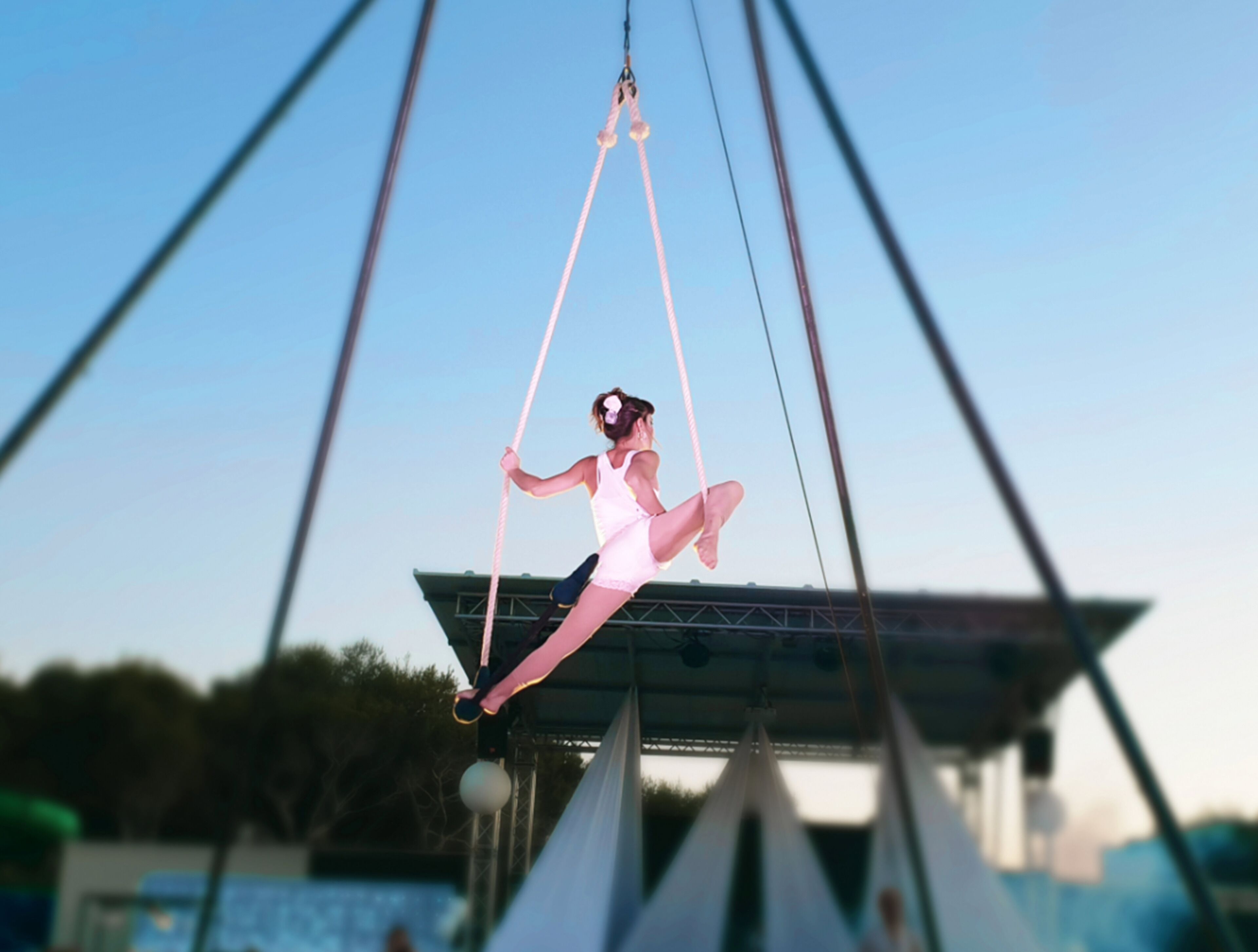 Uma pessoa fazendo acrobacias aéreas em uma barraquinha.
