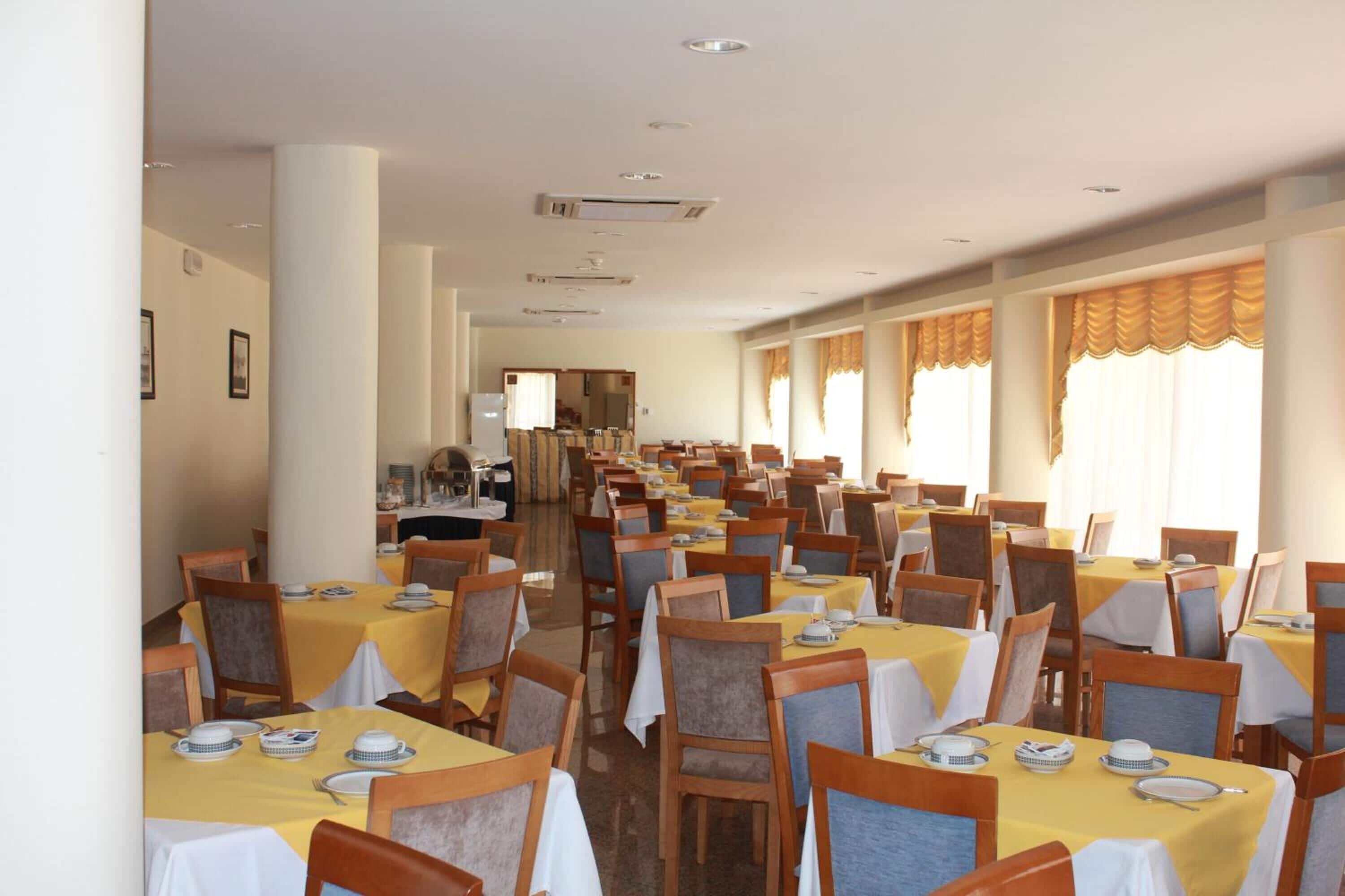 A large dining area with multiple tables and chairs, arranged in rows.