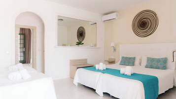 Habitació d'hotel amb dos llits, un mirall gran, un aparell d'aire condicionat i una decoració mural.