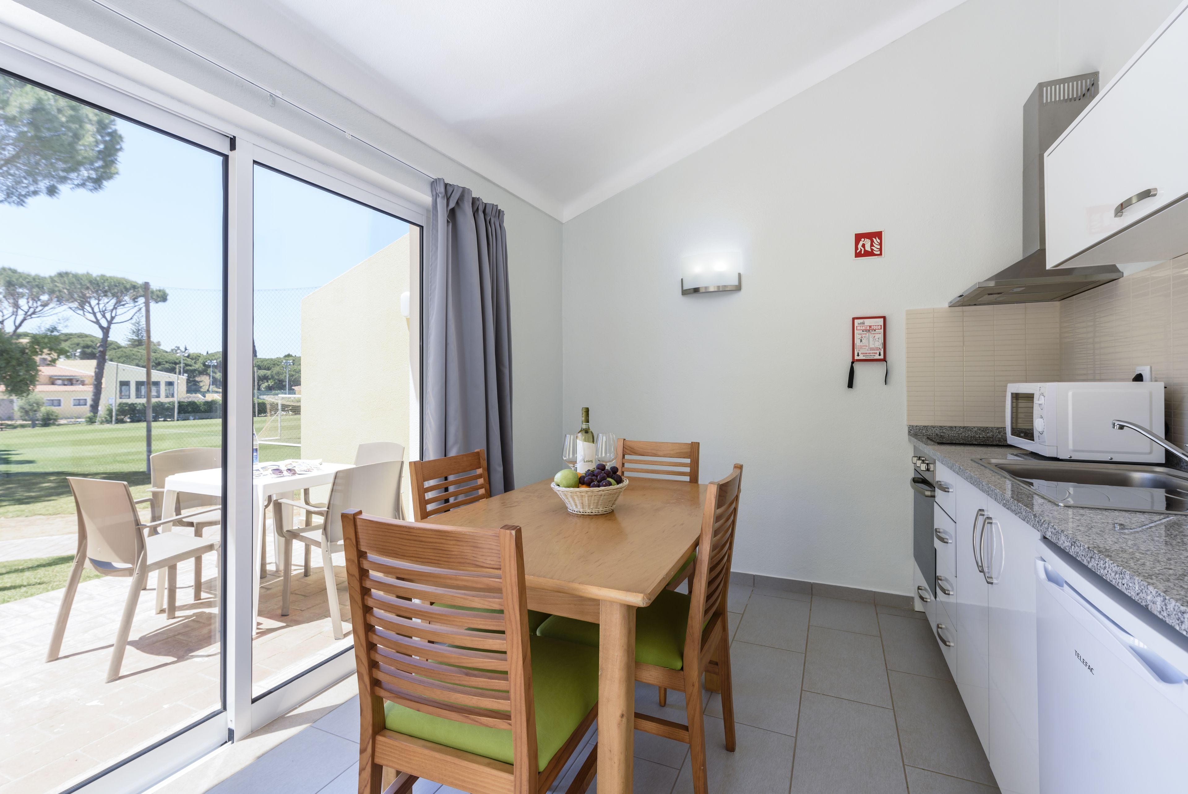 Uma cozinha moderna com área de refeições, vista para o exterior e um sinal de segurança contra incêndio.