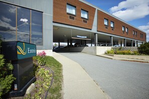 Enter through the contemporary entrance, where a wide pathway leads to the main entrance of this modern building.