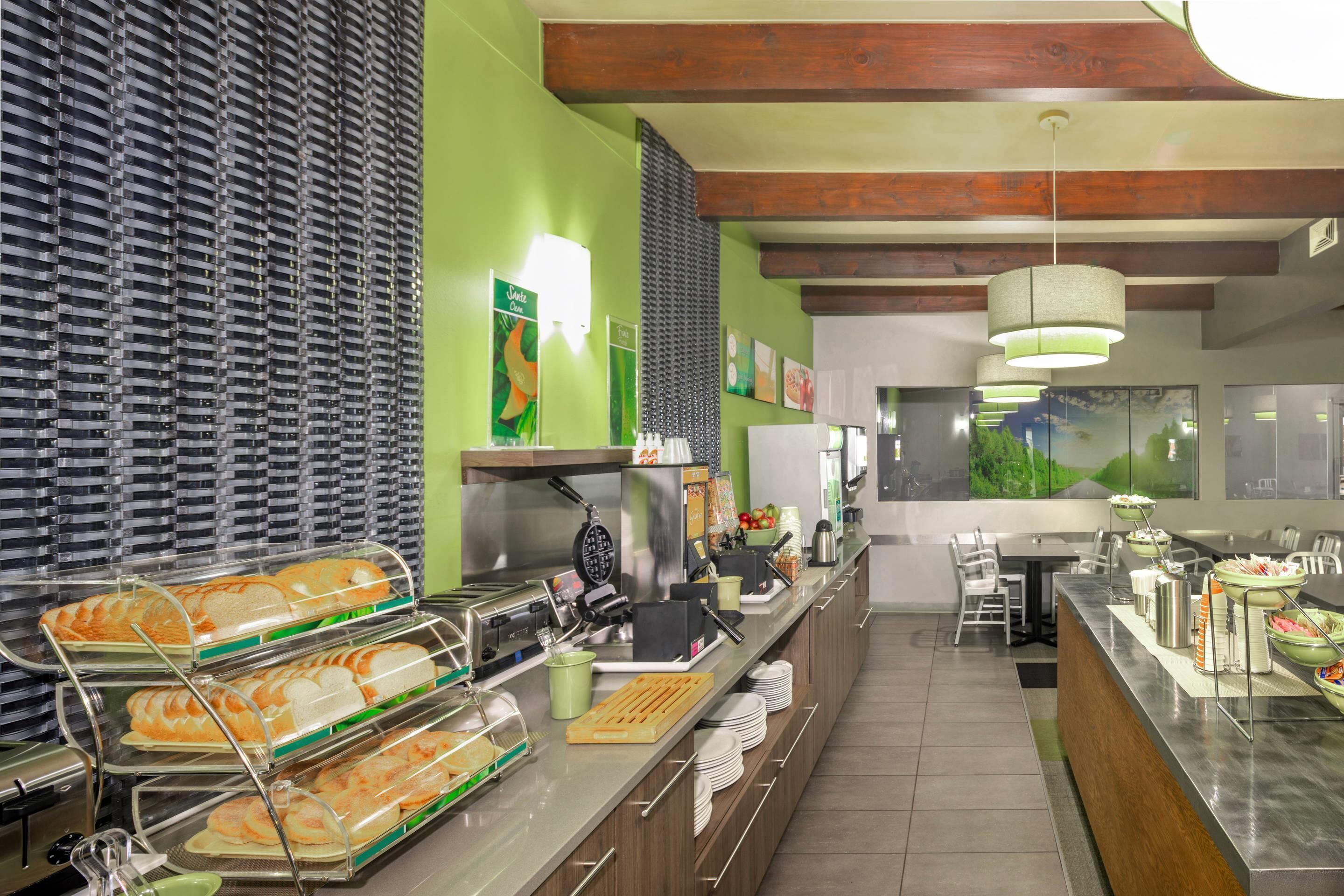 A buffet area with multiple serving stations, a kitchen area, and a seating area with tables and chairs.