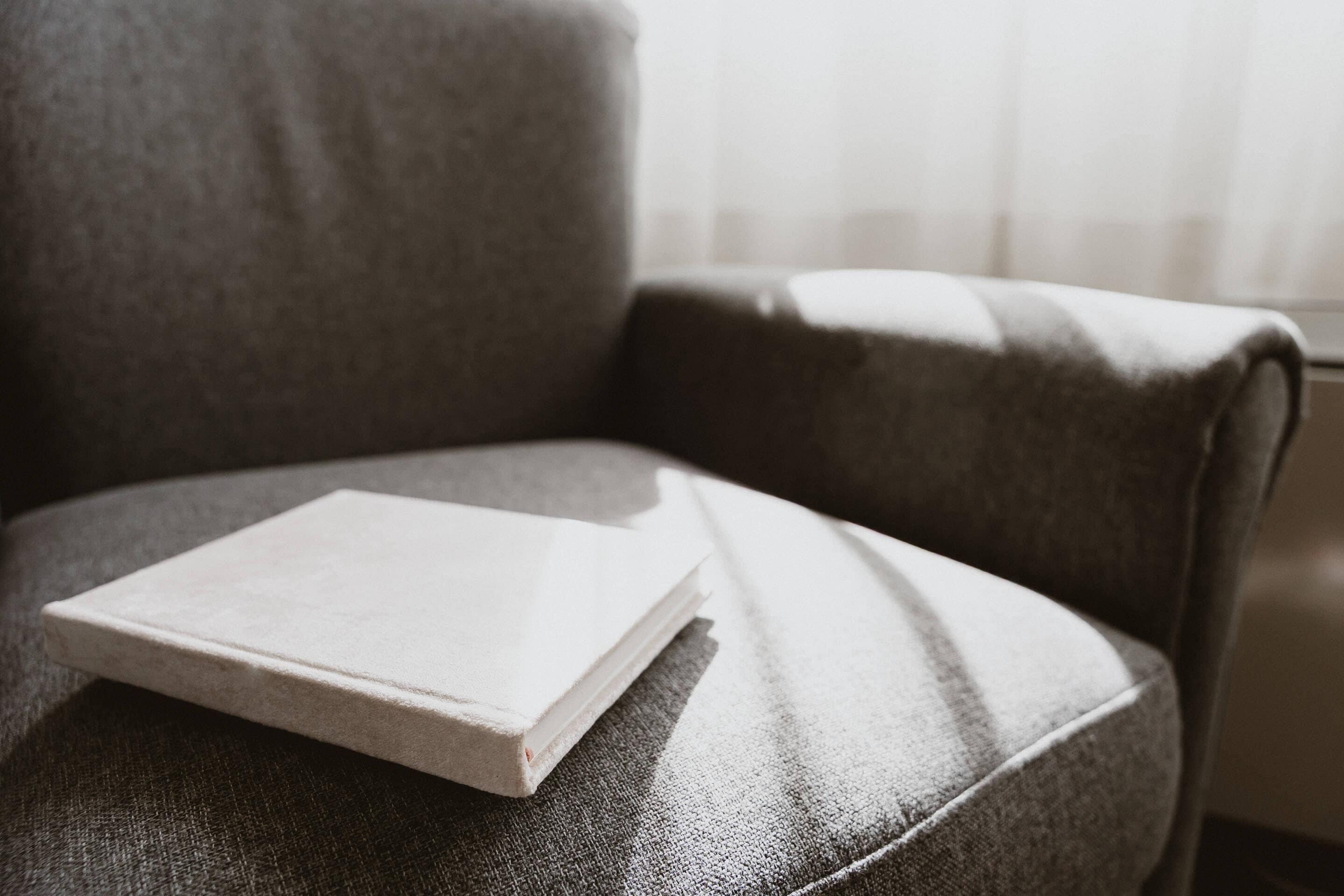 A book on a chair with a textured fabric.