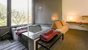 Ein modernes Badezimmer mit einer Badewanne, einer Holzbank und einem Handtuch auf der Bank.
