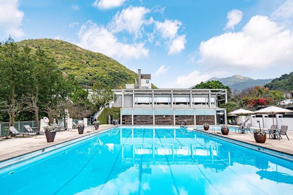 Un hôtel moderne doté d’une piscine, d’un espace extérieur aménagé et offrant une vue sur la montagne.