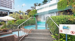 A pool area with a waterfall, stairs, and a sign indicating it is for adults only. - Bayview Beach Resort Penang (George Town)