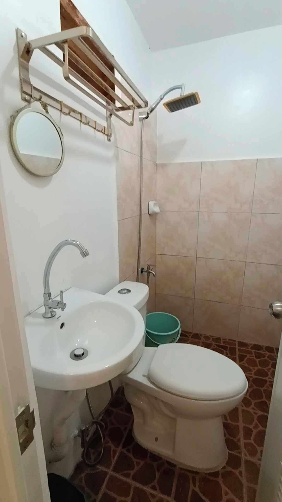 A small bathroom with a sink, toilet, and shower.