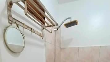 Um banheiro pequeno com pia, vaso sanitário e chuveiro.