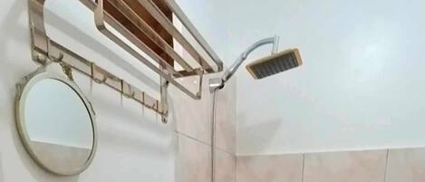 A small bathroom with a sink, toilet, and shower.