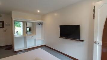 A modern hotel room with a large bed, a TV mounted on the wall, and a built-in wardrobe.