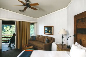 A hotel room with a bed, a sofa, a desk, a lamp, and a ceiling fan. - Sunnyside Restaurant & Lodge (Tahoe City)
