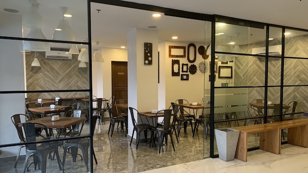 A modern interior with glass partitions, wooden tables, and chairs, and a marble floor. - Cebu R Hotel - Capitol (Cebu City)