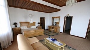 Een slaapkamer met een bed, een bank, een bureau en een stoel.