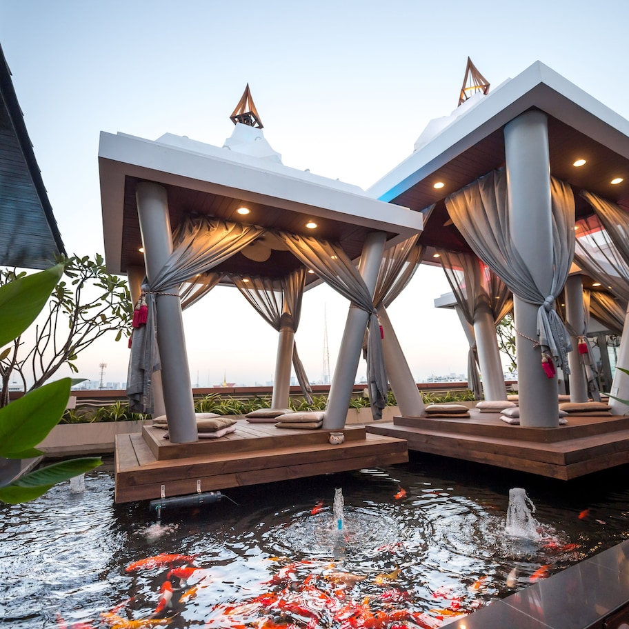 A modern outdoor seating area with a koi pond and water features.