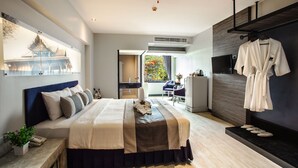 Una habitación de hotel moderna con una cama grande, un televisor, un balcón con vistas y un perchero para bata.