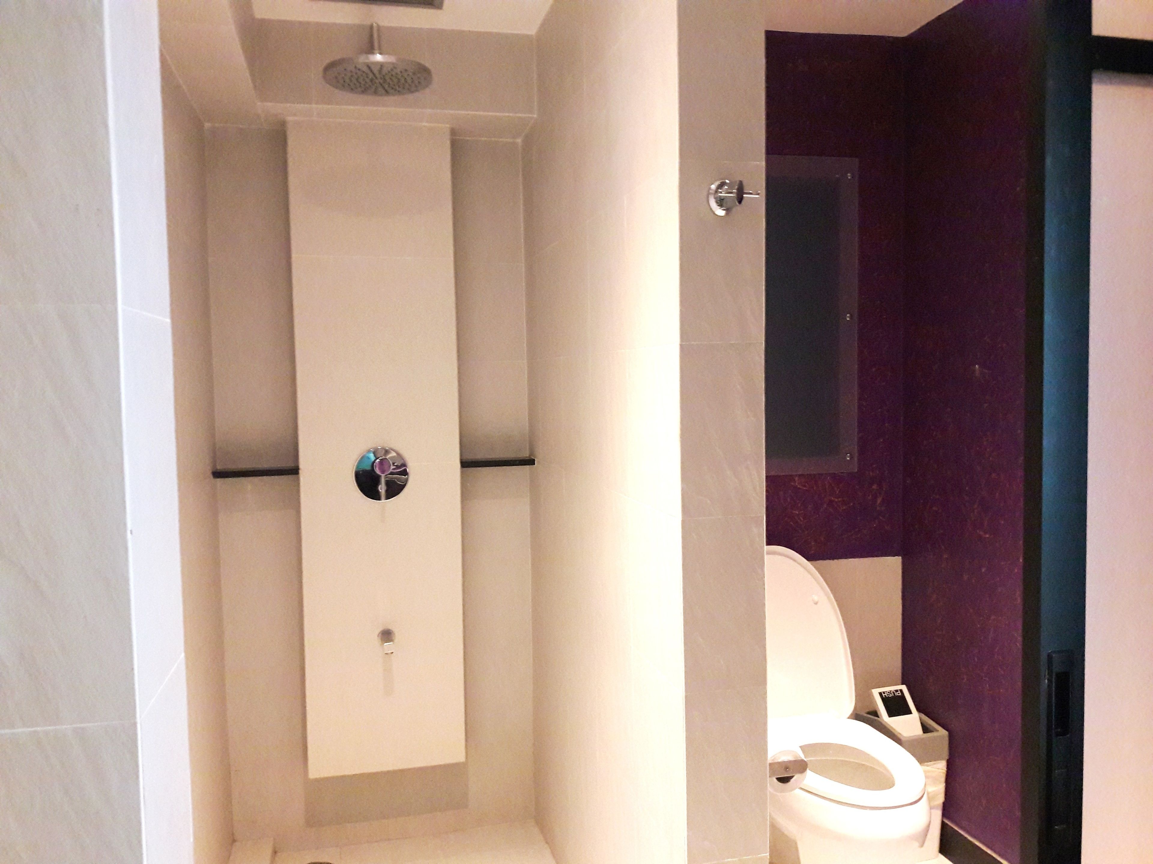 Un baño moderno con ducha, inodoro y tocador con espejo.
