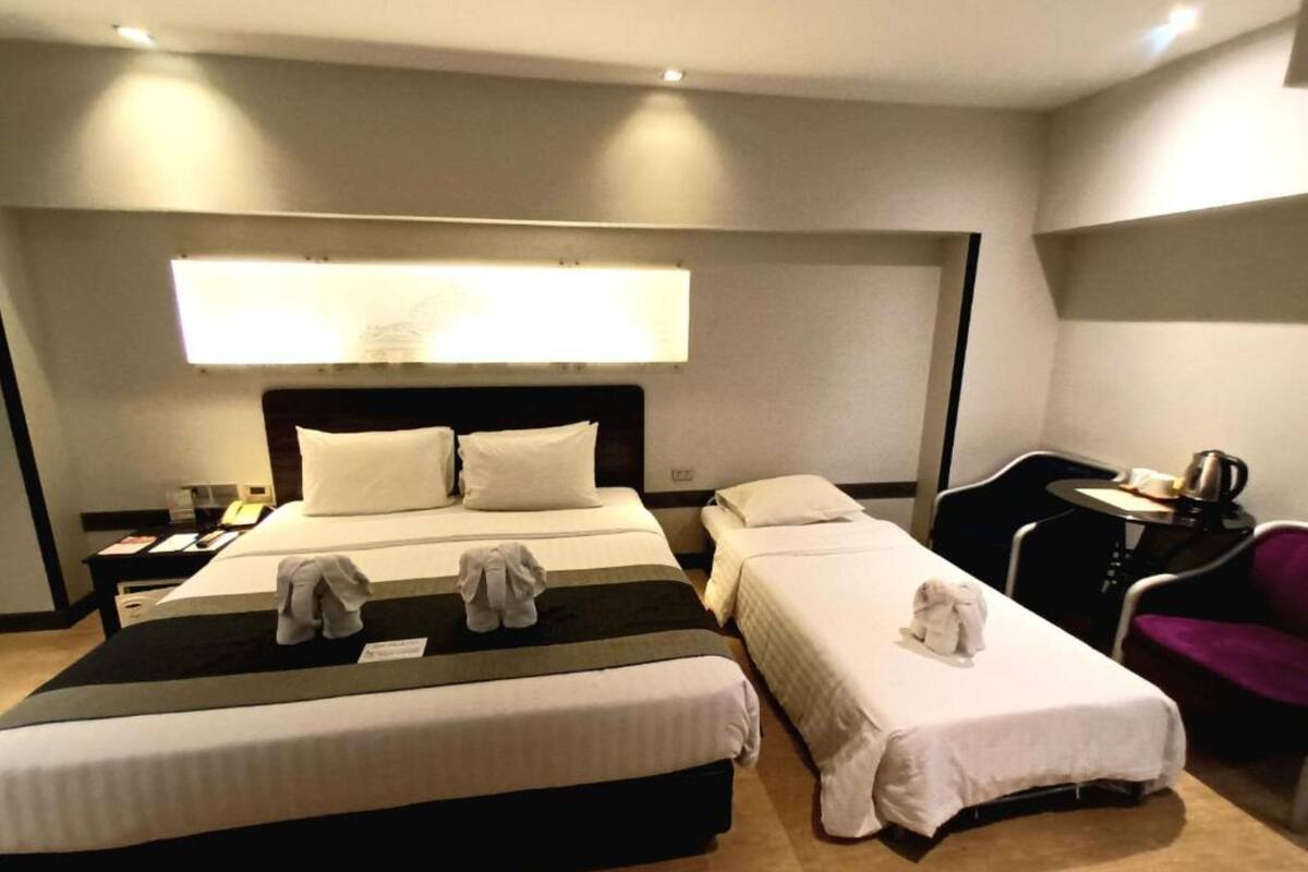 Een hotelkamer met twee bedden, een bureau, een stoel en een koffieapparaat.