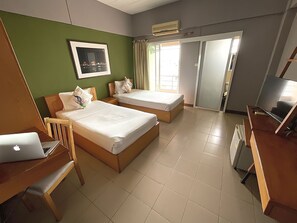 A hotel room with two beds, a desk with a laptop, a chair, a TV, and a window with curtains. - Plai And Herbs Suvarnabhumi Airport (Bang Phli)