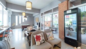 A modern hotel lobby with a pool table, comfortable seating, and a refrigerator stocked with beverages. - Plai And Herbs Suvarnabhumi Airport (Bang Phli)