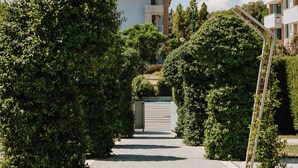 A pathway lined with greenery and modern buildings in the background. - Eden Hotel (San Salvo)