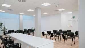 A conference room with a long white table, black chairs, and a potted plant. - Eden Hotel (San Salvo)