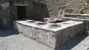 An ancient stone structure with a central stone platform and four circular stone basins.
