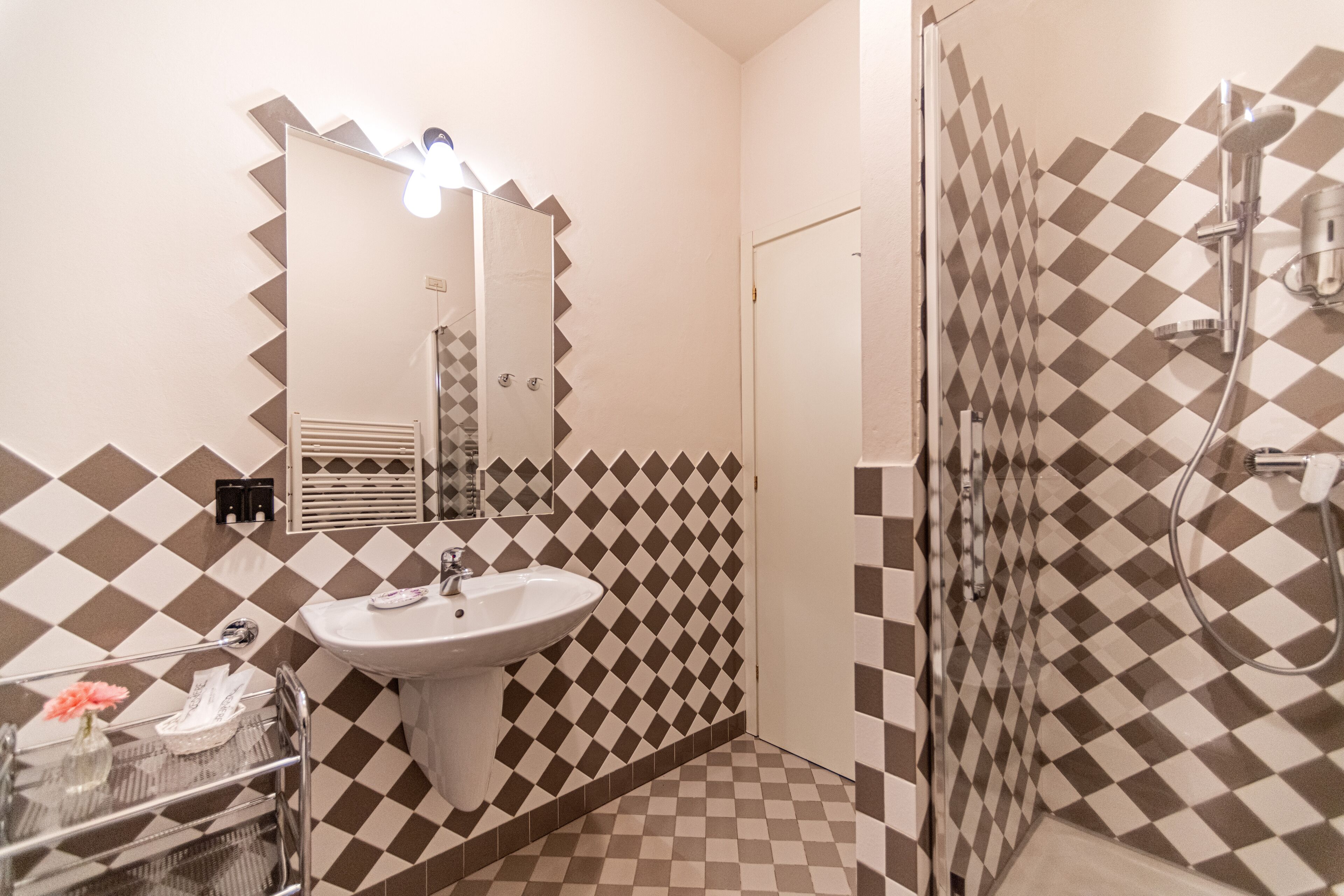 Un baño con lavabo, espejo y ducha.