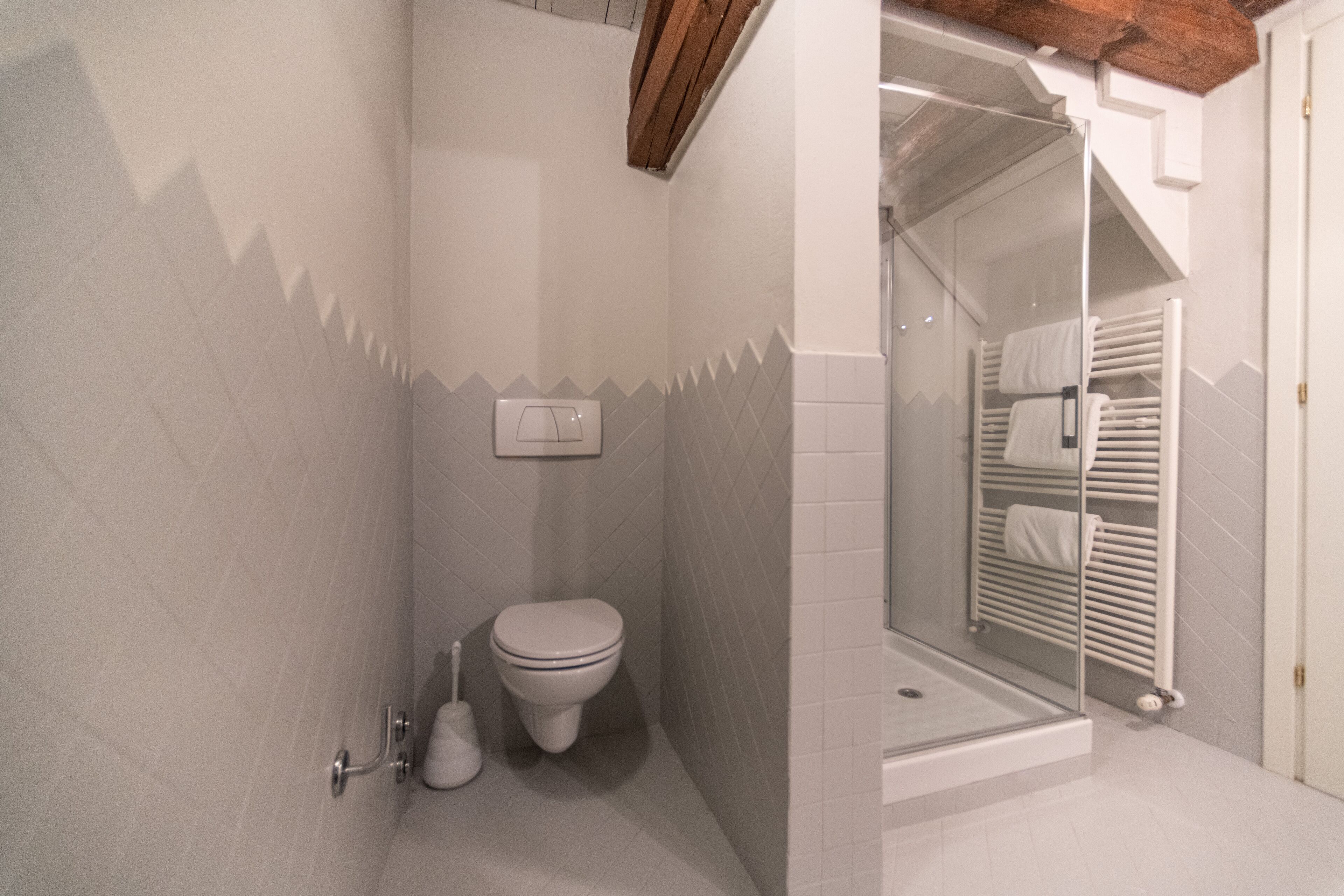 Un baño con inodoro, bidé y cabina de ducha de vidrio.