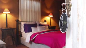 Un dormitorio con cama, dos lámparas de noche, una mesita de noche y una puerta con un llavero.