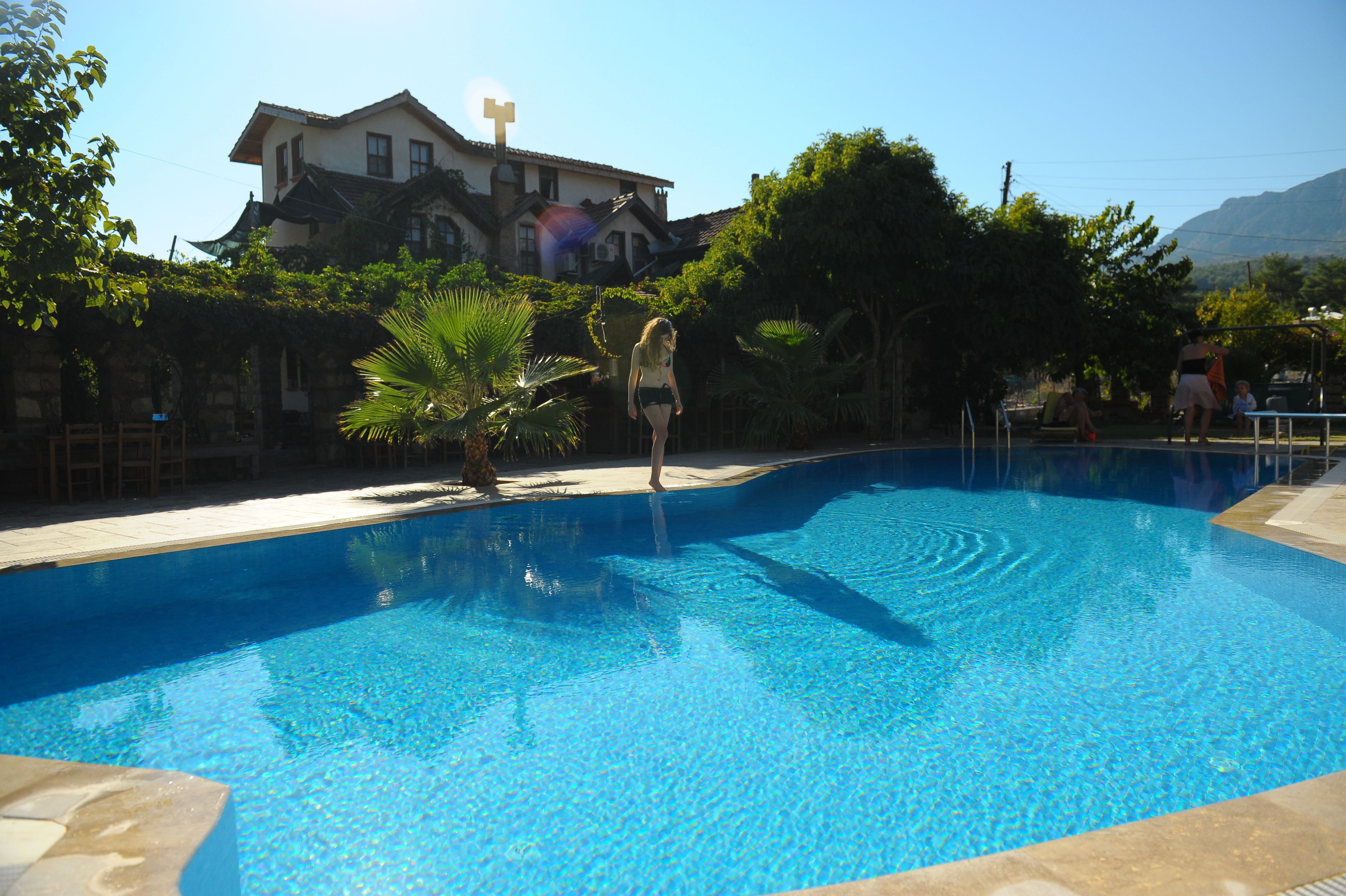 A swimming pool with a house in the background.