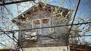A stone building with three arched windows and a wooden roof.