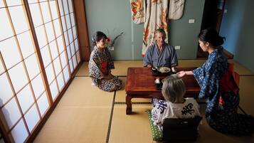 Una habitación japonesa tradicional con suelo de tatami, una mesa de madera baja y puertas correderas shoji.