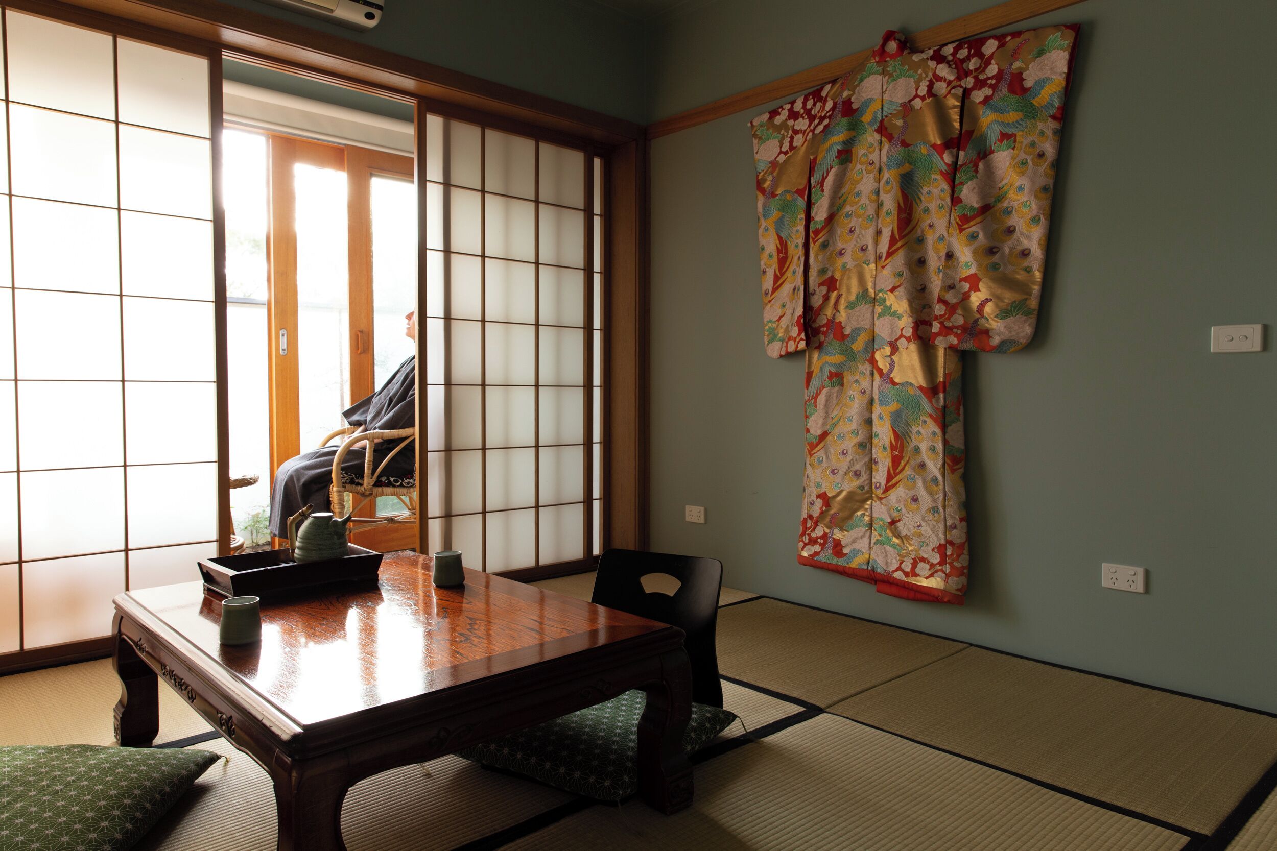 A traditional Japanese room with tatami flooring, a wooden table, and shoji screens.