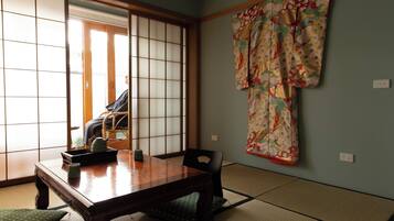 A traditional Japanese room with tatami flooring, a wooden table, and shoji screens.