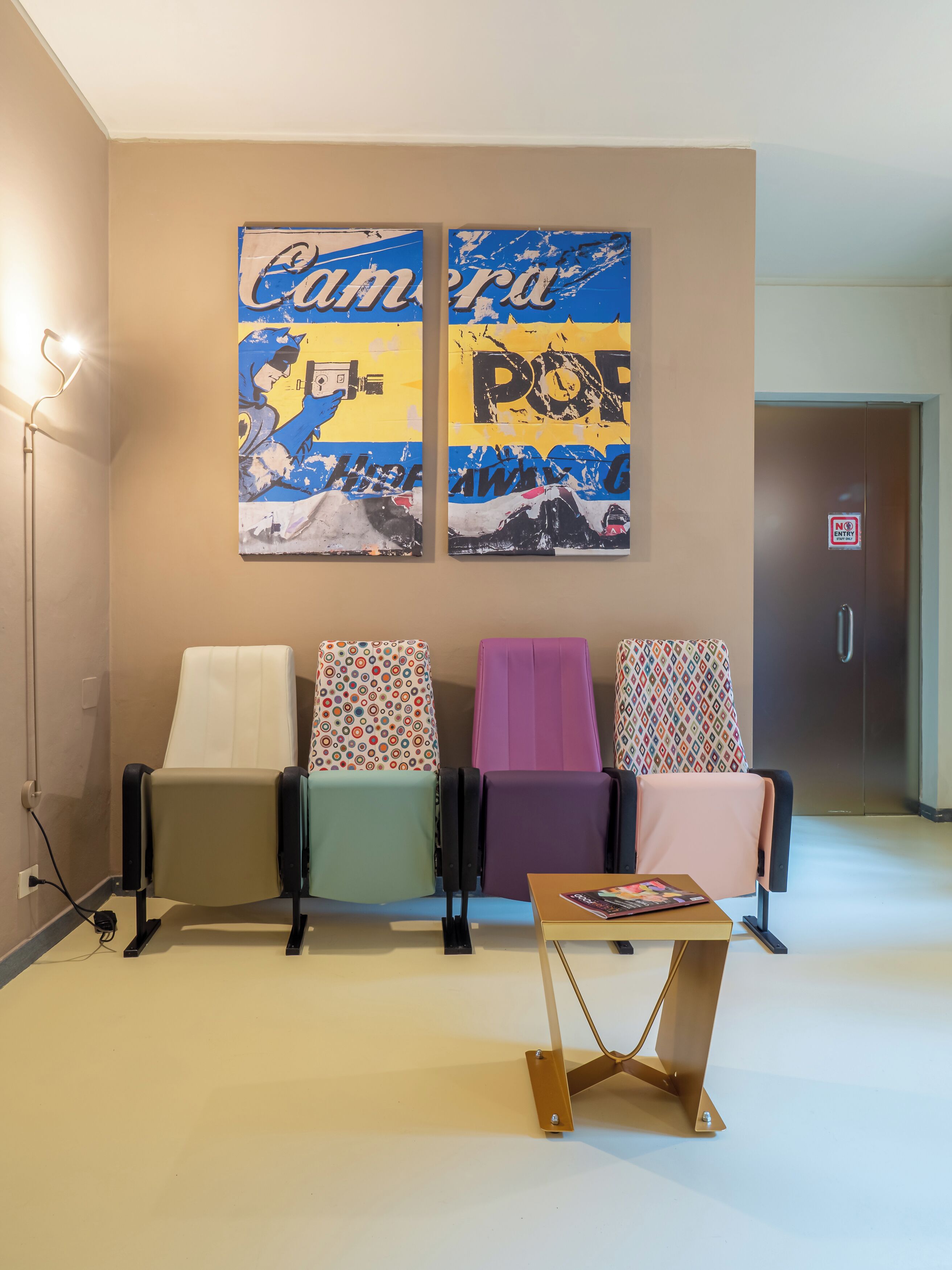 A waiting area with four chairs, a coffee table, and two wall art pieces.