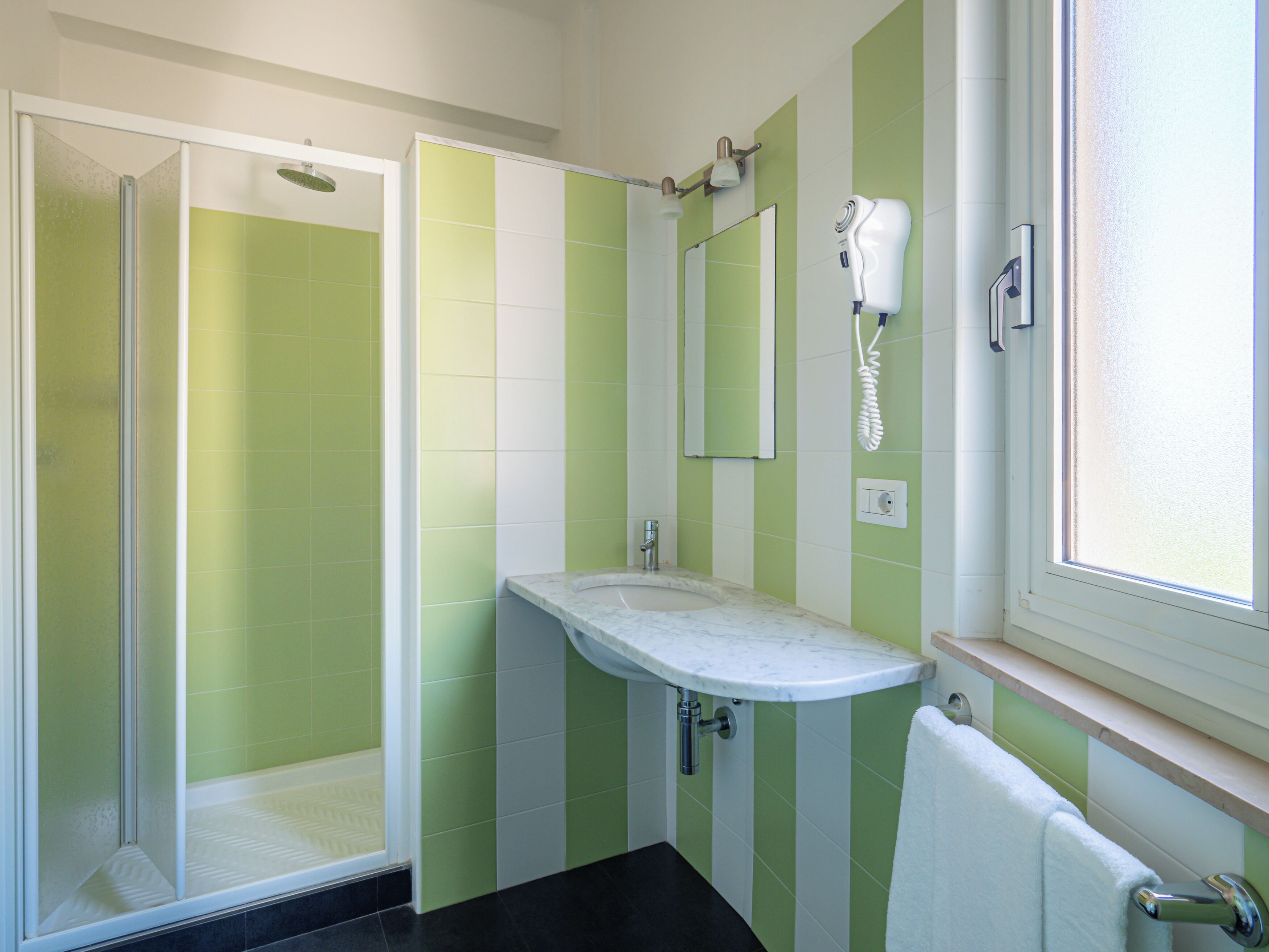 A bathroom with a shower, sink, and mirror.