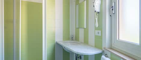 A bathroom with a shower, sink, and mirror.