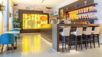 A modern bar area with a bar counter, multiple seating options, and a variety of bottles.