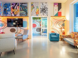 Una sala de estar moderna con arte abstracto en la pared, una estantería y asientos cómodos.