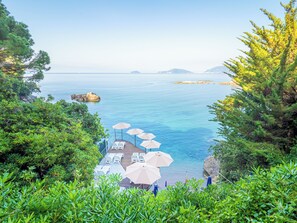 A coastal terrace with outdoor seating and umbrellas overlooking the sea. - Hotel il Nido (Lerici)